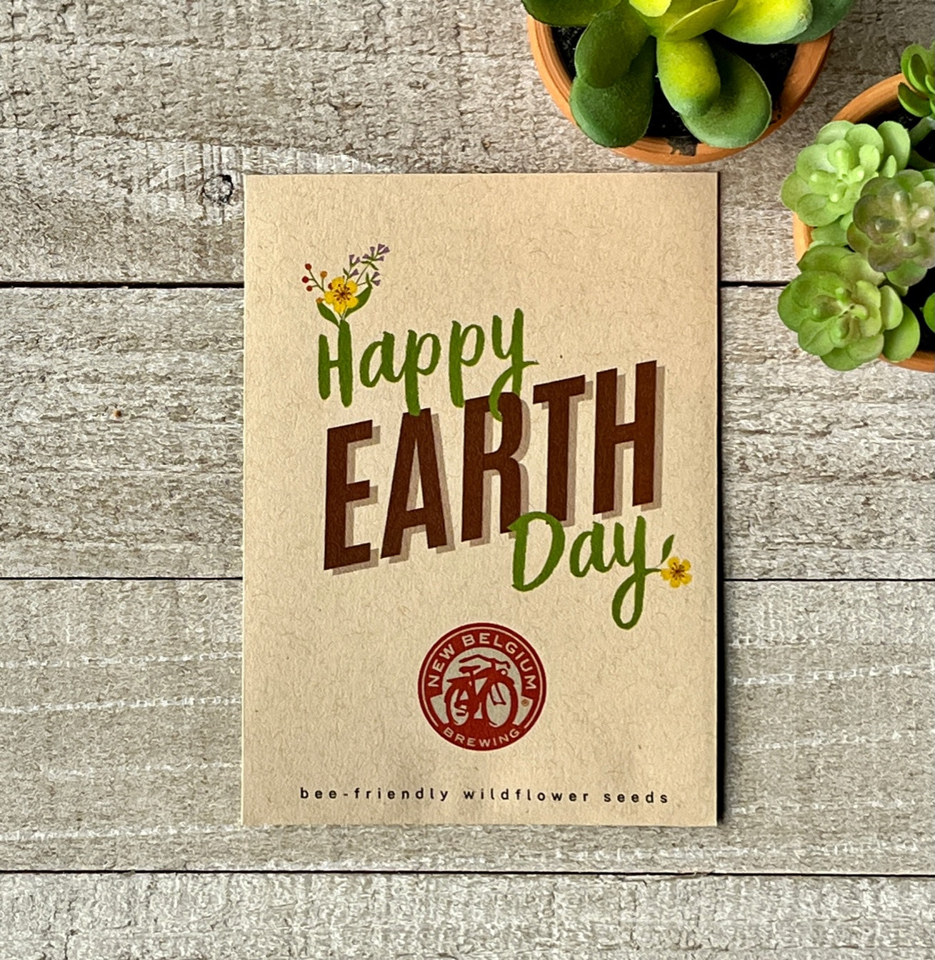 A brown seed packet that says "Happy Earth Day," and a corporate logo.