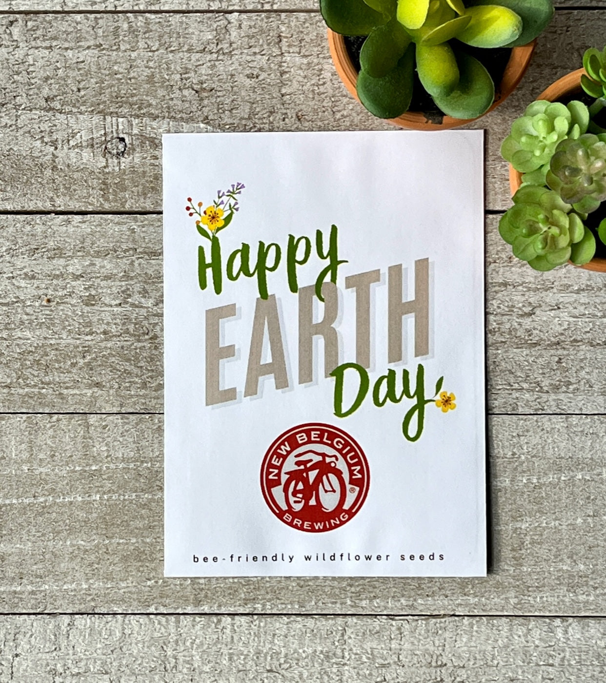 A white seed packet that says "Happy Earth Day," and a corporate logo.