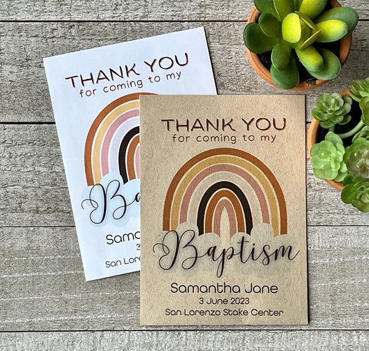 A white and brown seed packet with a rainbow and the words, thank you for coming to my baptism.