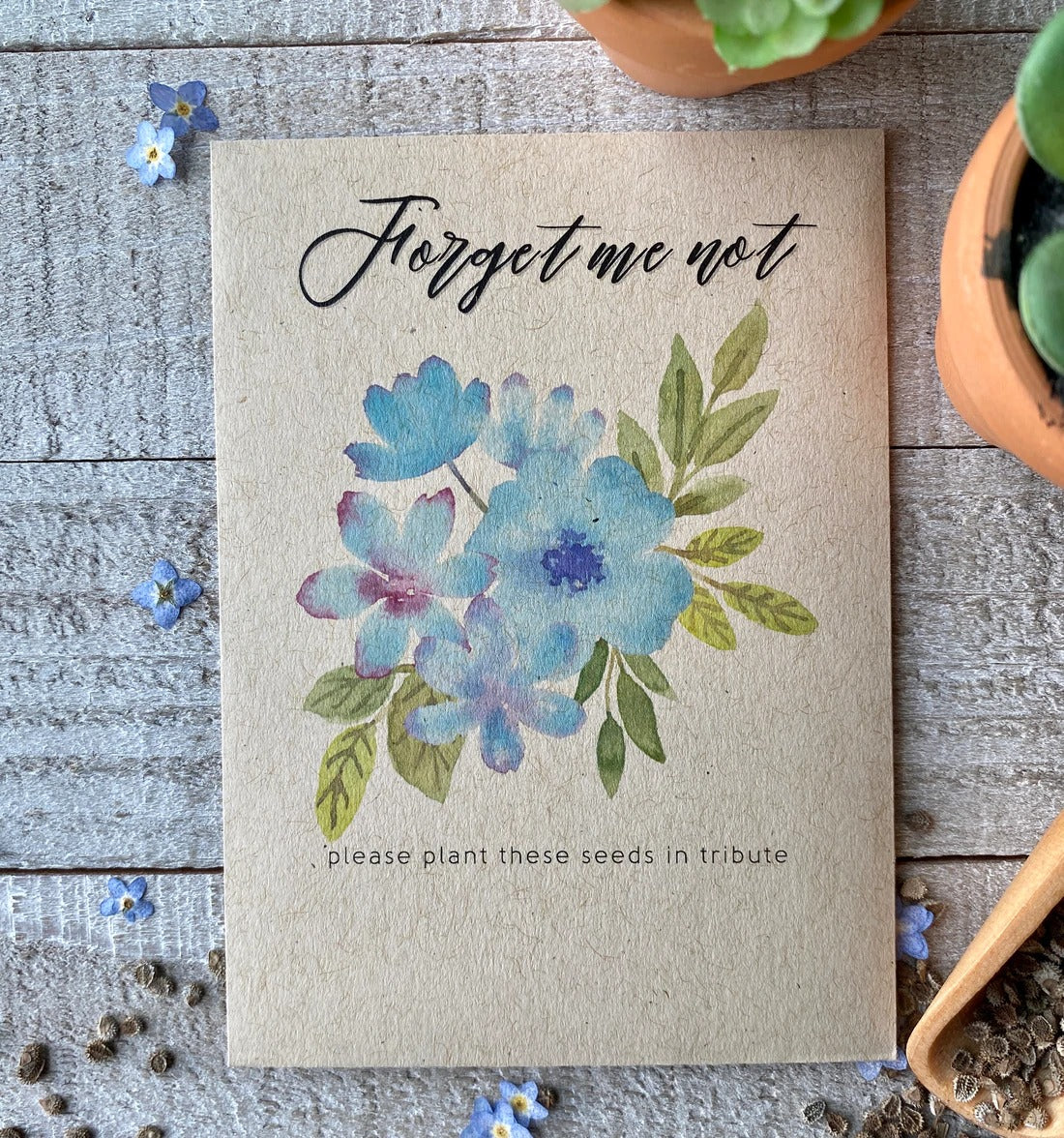 A brown seed packet with blue, watercolor flowers and "forget me not" written on top.